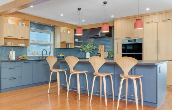 A kitchen with blue cabinets and stools.