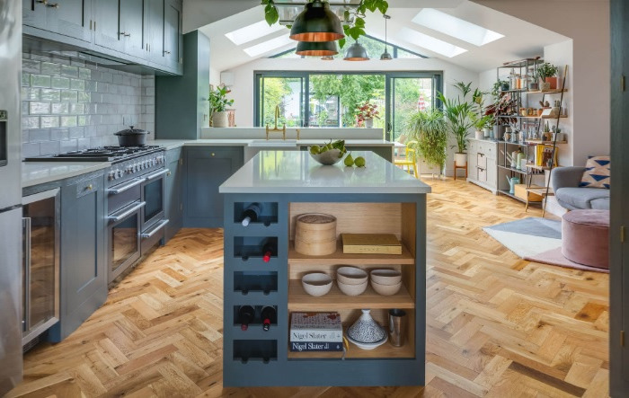 A kitchen with blue cabinets and wooden floors.