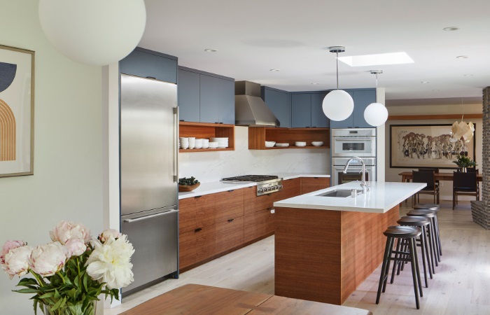 A modern kitchen with blue cabinets and wooden counter tops.