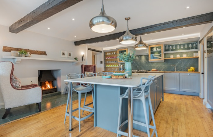 A kitchen with a large island and a fireplace.