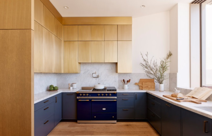 A blue and gold kitchen with wooden floors.