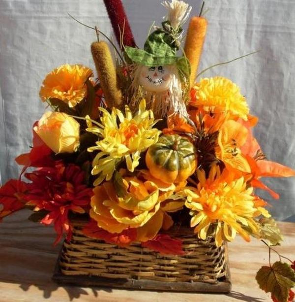 A wicker basket filled with flowers and a scarecrow.