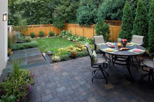 A small backyard with a table and chairs.