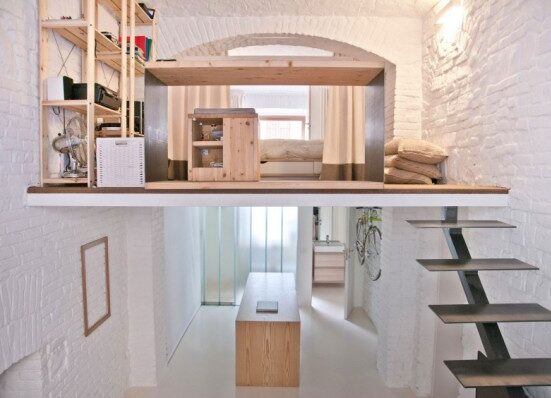 A small room with a loft and stairs.