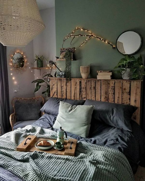 A bedroom with green walls and a wooden bed.