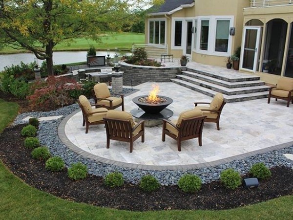 A backyard with a fire pit and patio furniture.