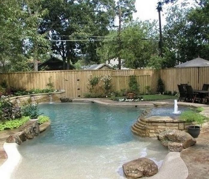 A backyard with a pool and a waterfall.