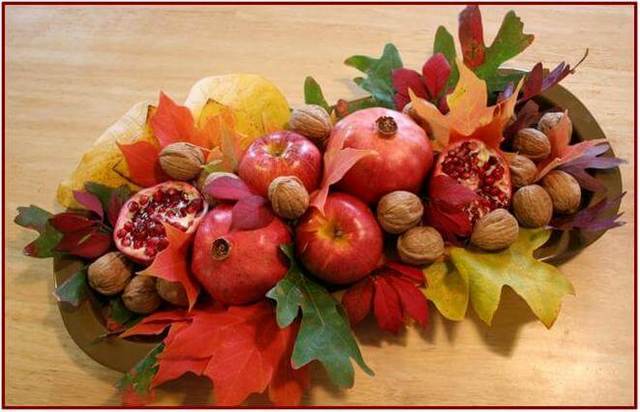 An arrangement of fall fruits and nuts on a table.