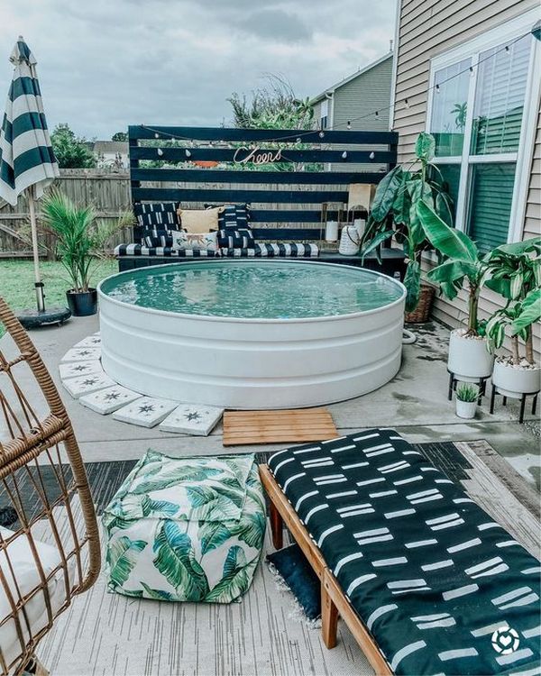 A backyard with a pool and lounge chairs.