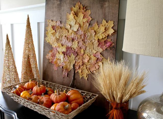 A mantle with a basket of pumpkins and fall leaves.