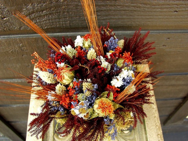 A bouquet of dried flowers on top of a wooden box.