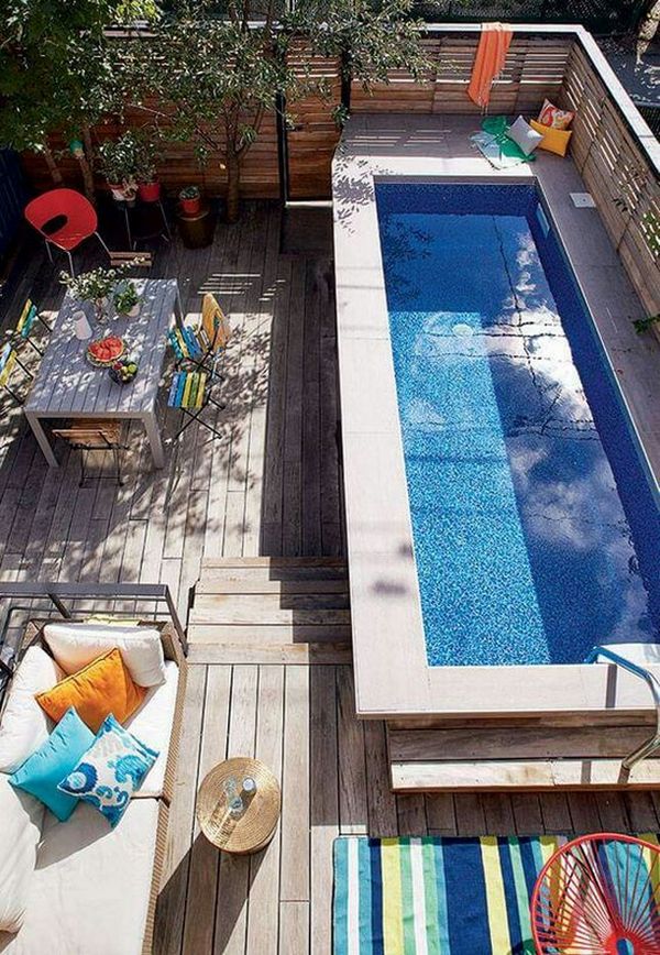 A backyard with a swimming pool and patio furniture.