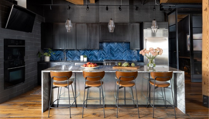 A kitchen with a blue backsplash and stools.