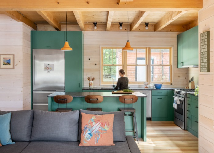 A kitchen in a tiny house with green walls.