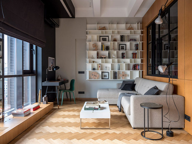 A living room with wooden floors and a bookcase.