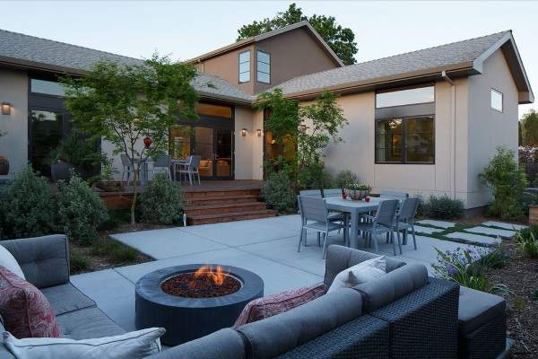 A backyard with a fire pit and couches.