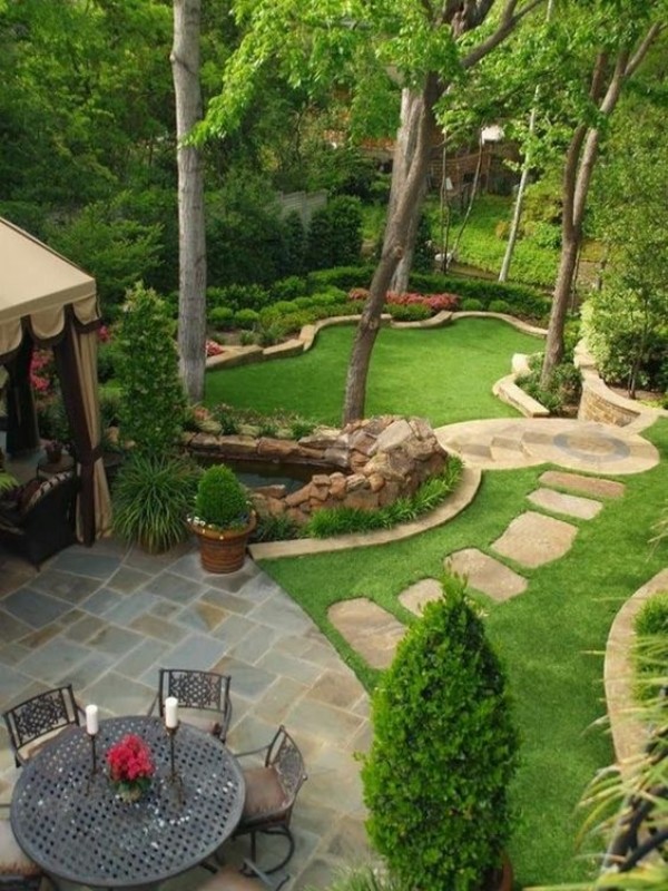 A backyard with a patio and grass.