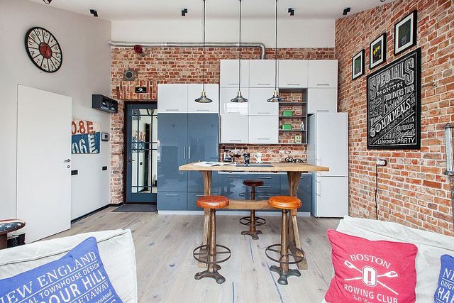 A kitchen with a brick wall and a bar stools.