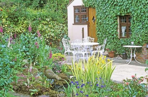 A small garden with a table and chairs.