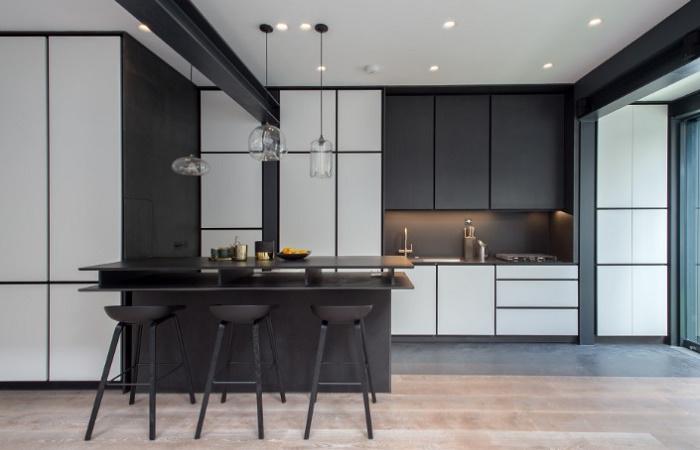 A black and white kitchen with bar stools.