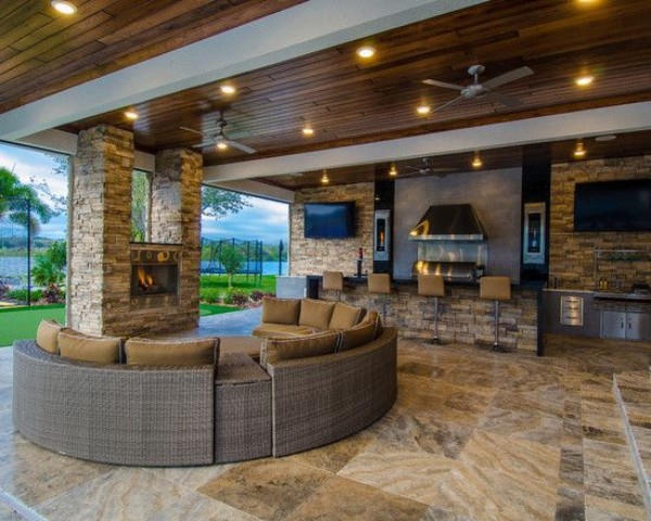 A large outdoor living area with a fireplace and tv.