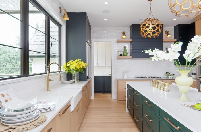 A kitchen with green cabinets and white counter tops.