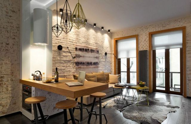 An apartment with a brick wall and wooden floors.