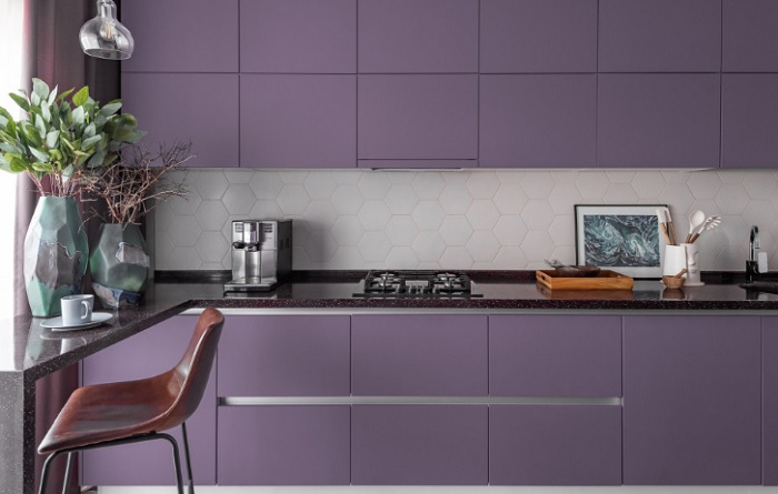 A kitchen with purple cabinets and white counter tops.