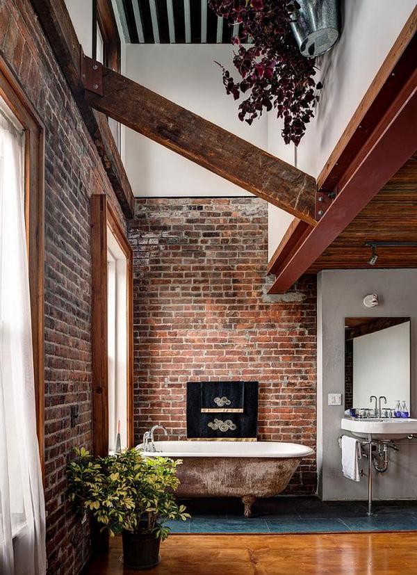 A bathroom with a brick wall and a tub.