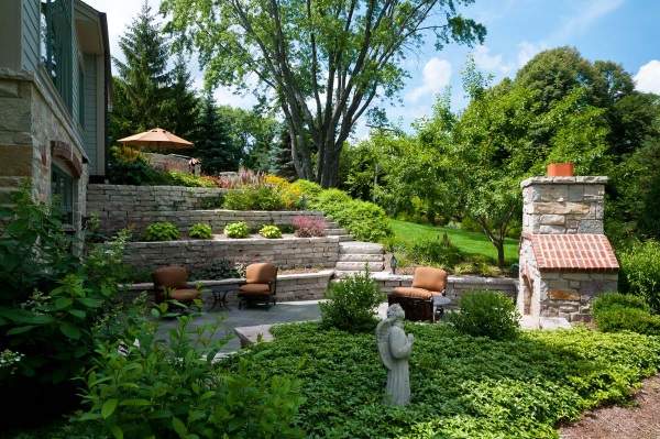 A backyard with a stone patio and landscaping.