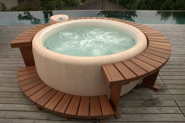 A wooden hot tub sitting on top of a wooden deck.