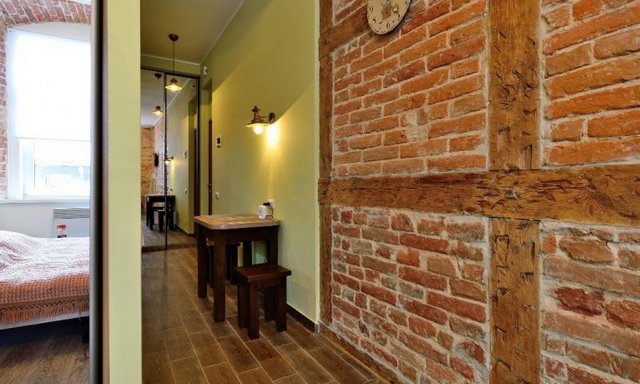 A room with a brick wall and a bed.