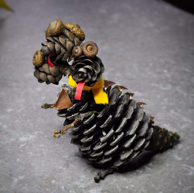 A pine cone with a bird on it.