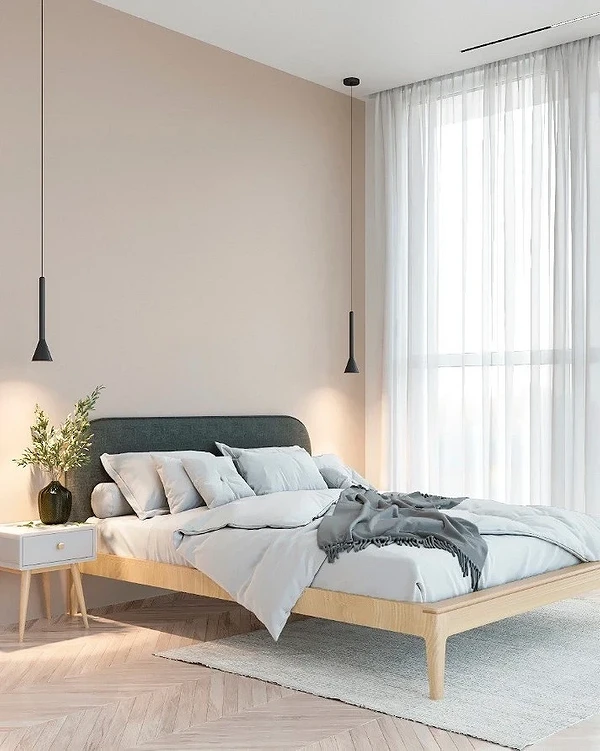 A modern bedroom with beige walls and wooden floors.