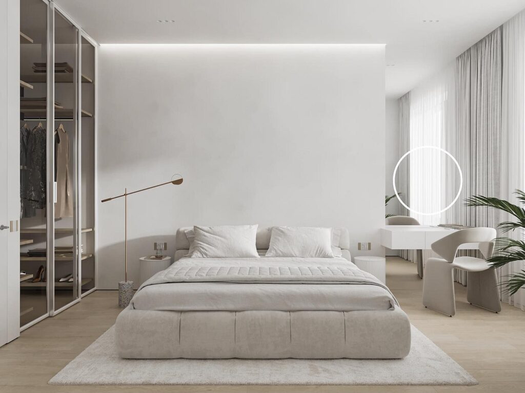 A modern bedroom with white walls and a white bed.