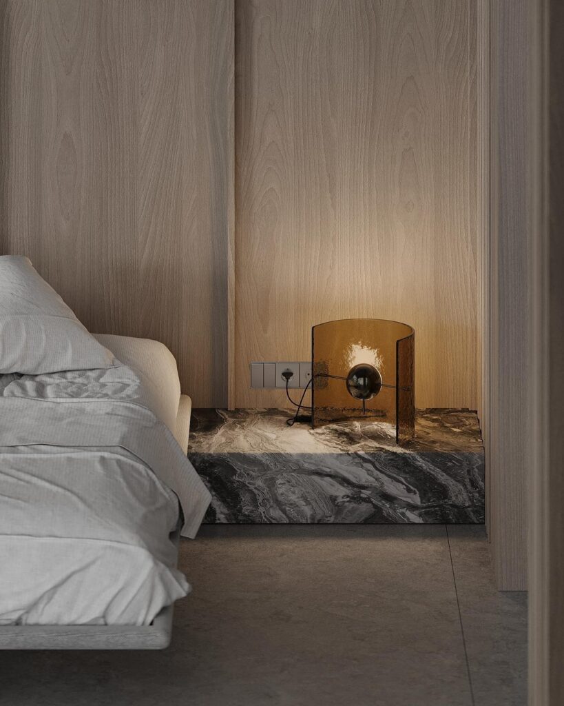 A bedroom with a bed and a bedside lamp.