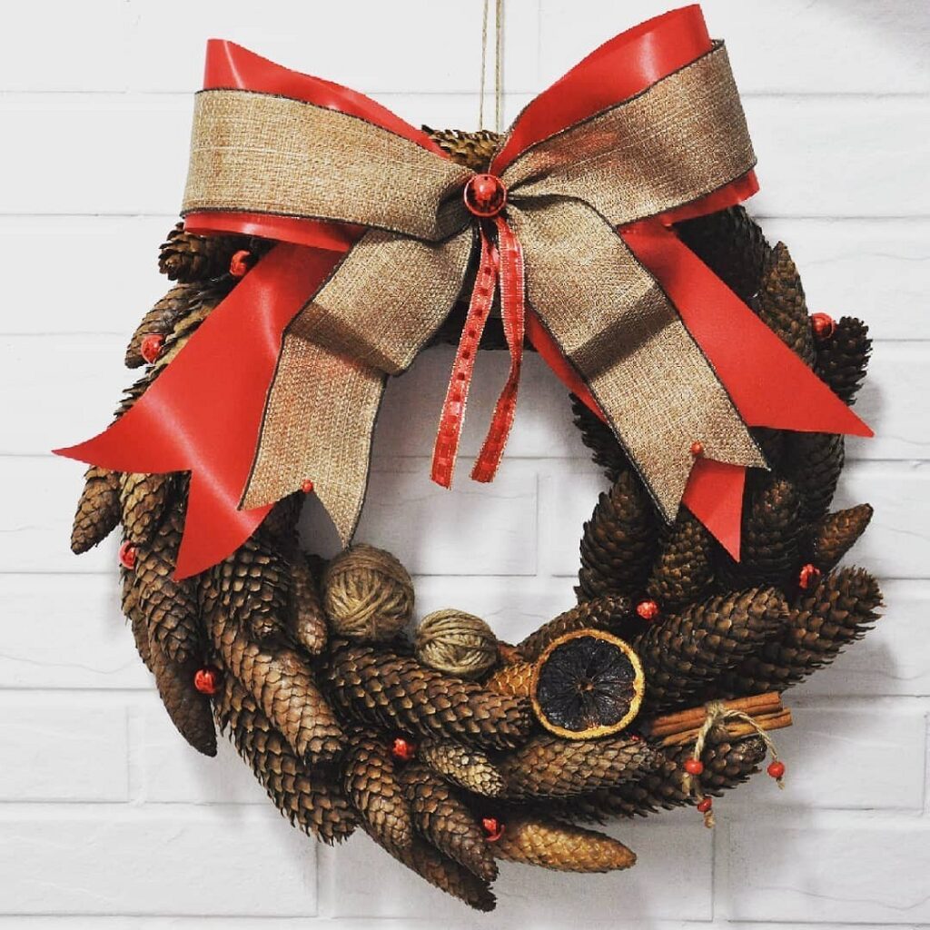 A christmas wreath hanging on a brick wall.