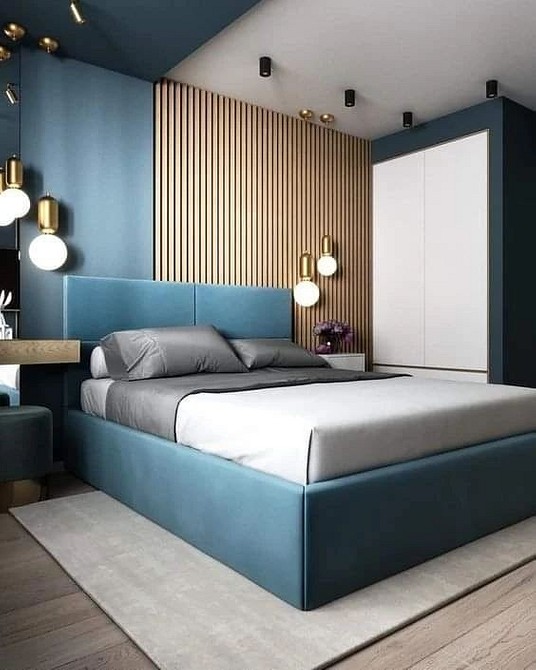 A bedroom with blue walls and gold accents.