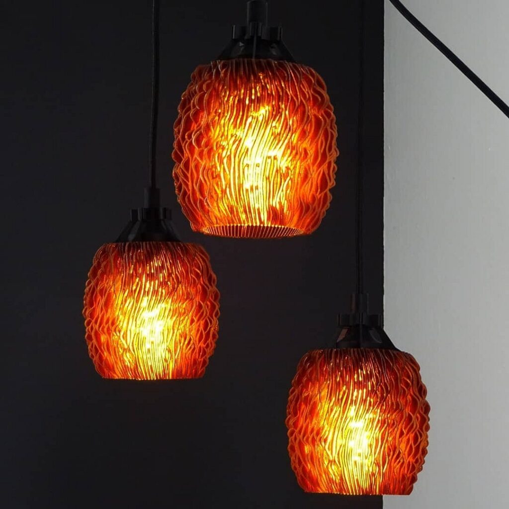 Three light fixtures hanging from a black wall.