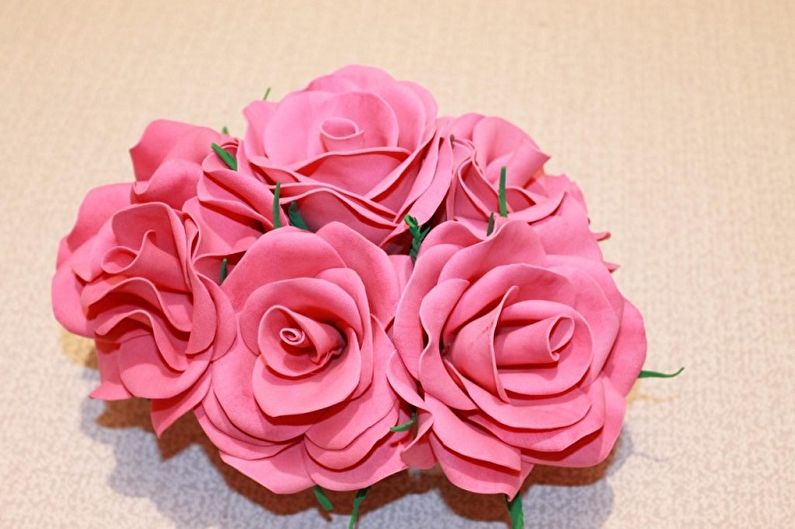 A bouquet of pink paper roses on a table.