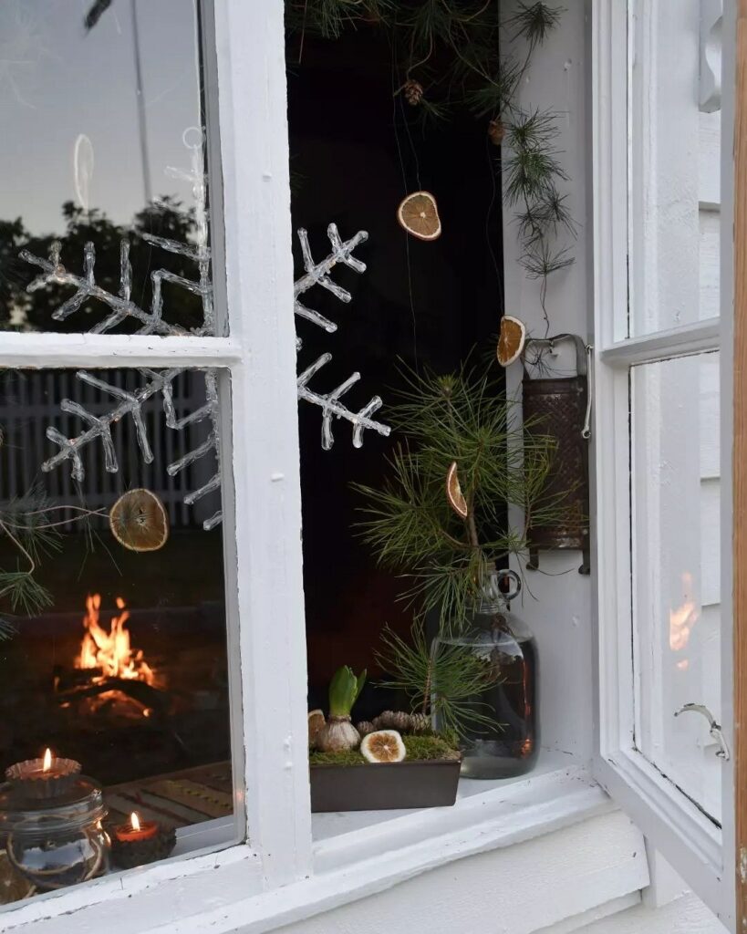 A window with a fireplace and snowflakes on it.