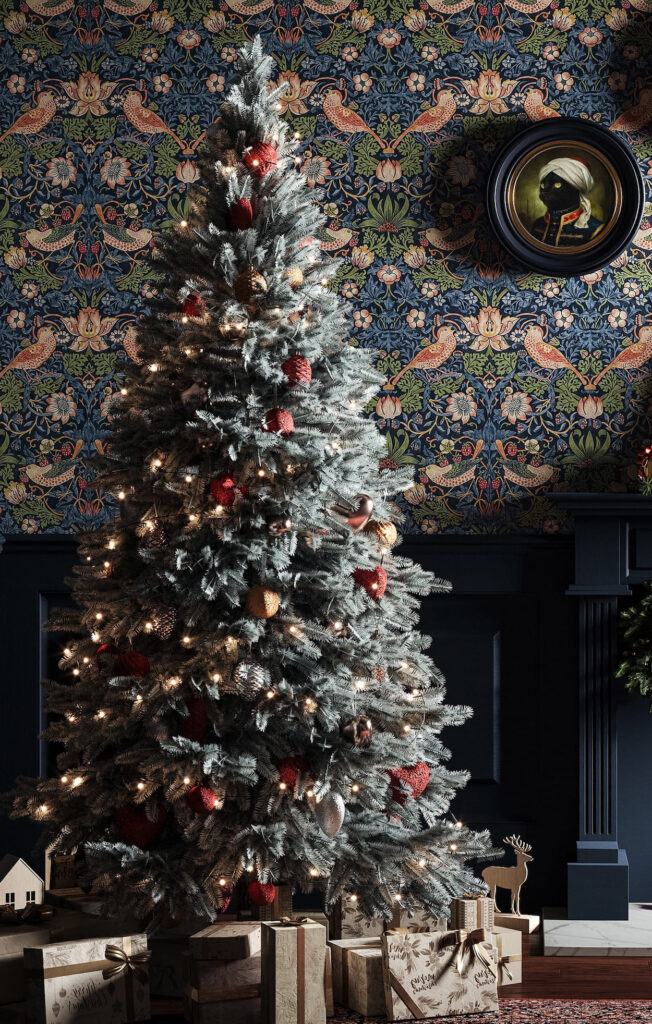 A christmas tree in front of a blue wallpaper.