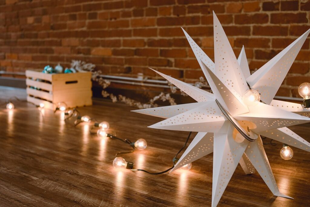 A christmas star on a wooden floor with lights.