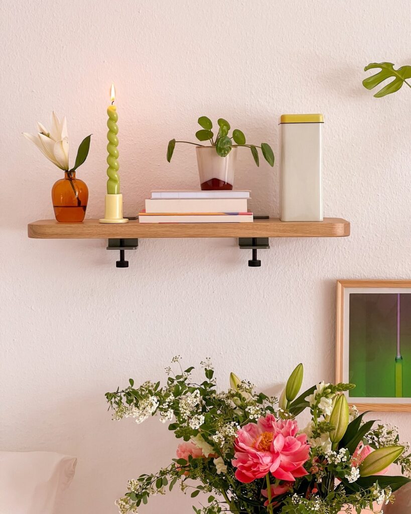 A shelf with plants and flowers on it.