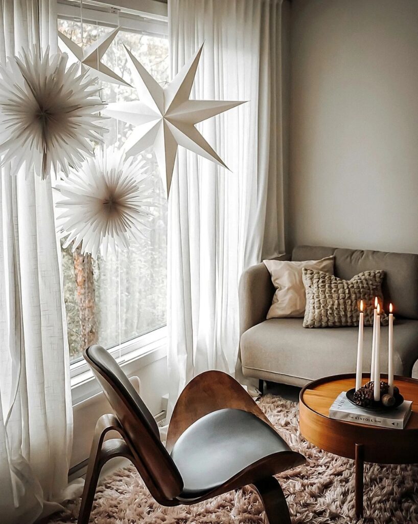 A living room with white curtains and star decorations.