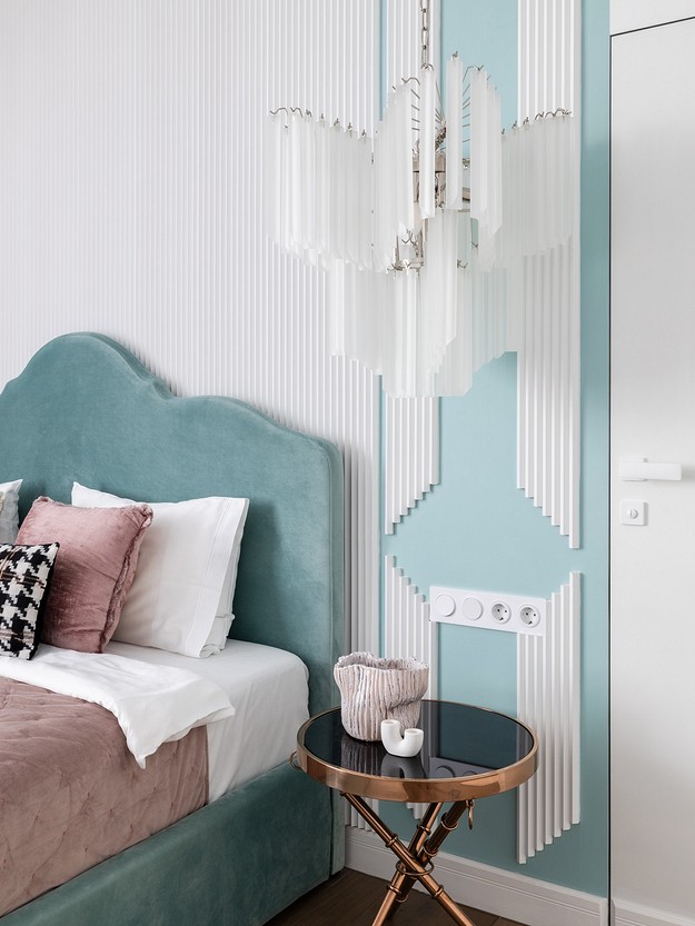 A blue and white bedroom with a chandelier.