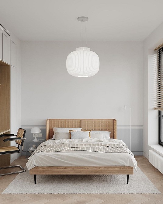 A modern bedroom with white walls and wooden floors.