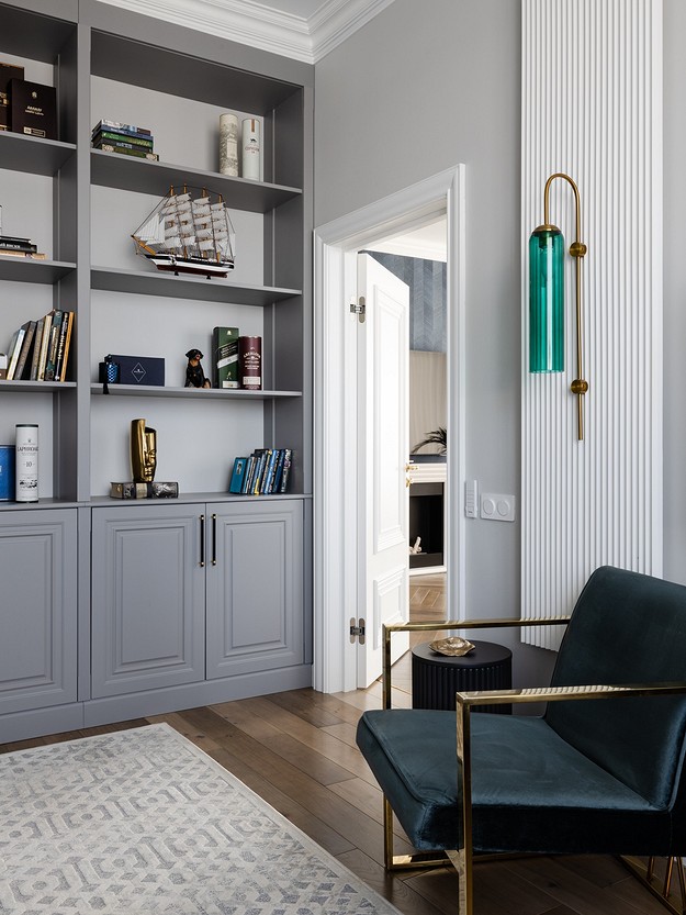 A living room with bookshelves and a blue chair.