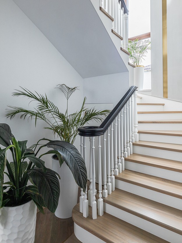 A white staircase with a potted plant on it.