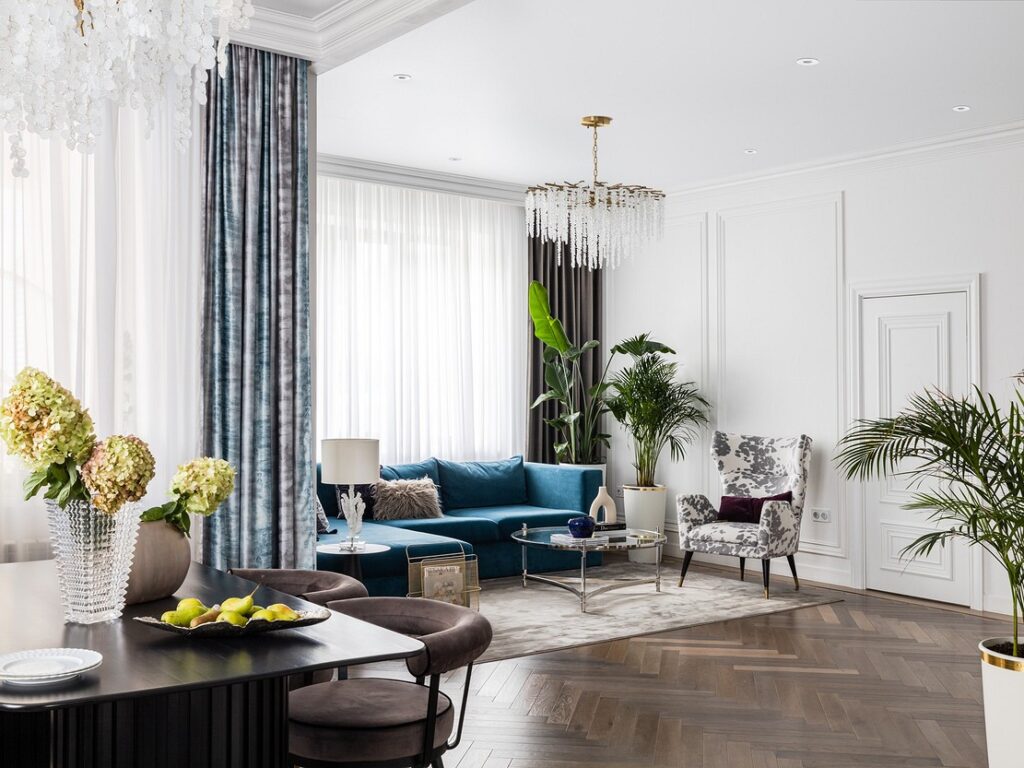 A living room with blue furniture and a chandelier.